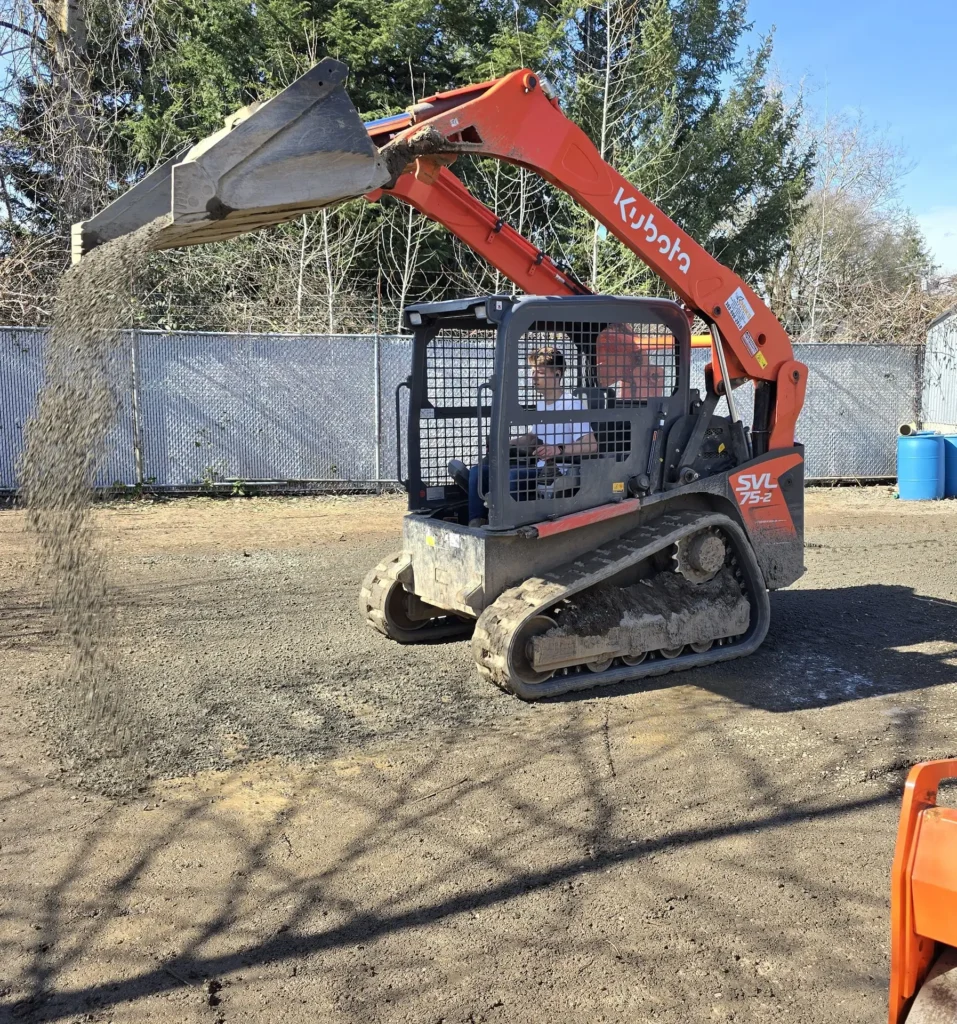 A bulldozer fills the area with yaba to level the area.